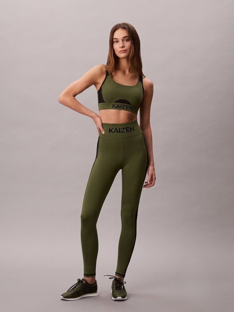 Design visualisation of the planned crop top and legging set: olive green with black side panels, black contrast trim at the ankle, and a black KAIZEN waistband on both pieces.