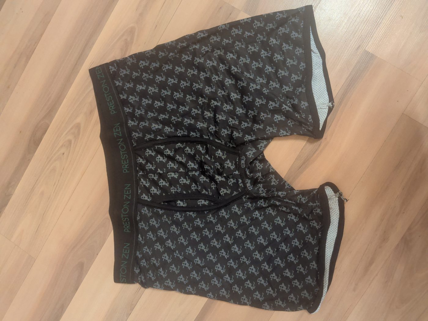 The Preston Zen boxer brief laid flat, showing the full monogram print, the contrast fly panel and the perforated mesh lining at the leg openings.